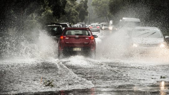 Cars drive along flooded roads in Five Dock on Tuesday. 