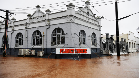 Billions of dollars of properties, such as this NSW business hit by flooding in 2022, are at high risk of flood and bushfire.