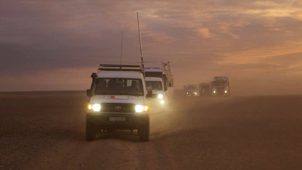 A convoy of vehicles of the Syrian Arab Red Crescent takes aid supplies across the Syrian desert to Rukban camp between the Jordan and Syria borders in 2018.
