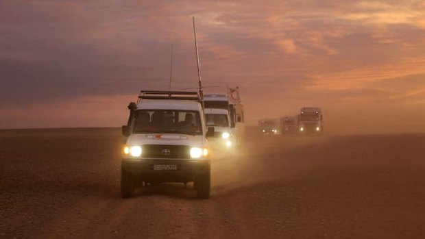 A convoy of vehicles of the Syrian Arab Red Crescent takes aid supplies across the Syrian desert to Rukban camp between the Jordan and Syria borders in 2018.