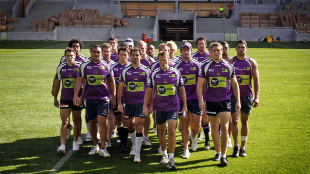 Surrounded by all 22 players, Melbourne Storm coach Craig Bellamy approaches the cameras to talk about the future of the club in light of the penalties handed out by the NRL for systematic cheating of the salary cap.