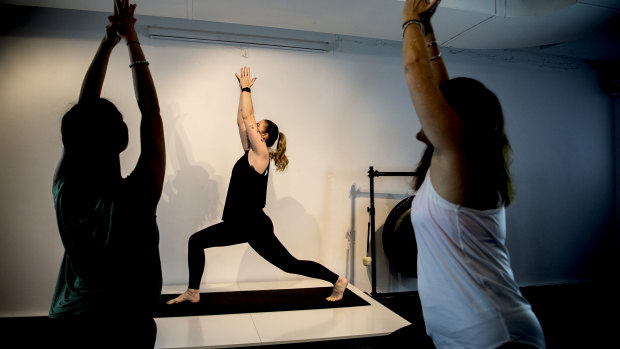 Casey Castro with students Manuela Pamlumbo and Adette Kagan as Sydney Yoga Collective prepares to re-open.