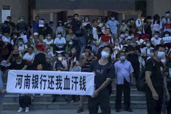 Angry bank customers protest at the entrance of a branch of China’s central bank in Zhengzhou on Sunday.