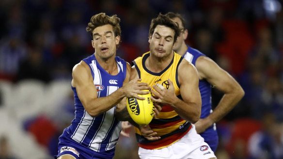 North Melbourne’s Jy Simpkin and Adelaide’s Darcy Fogarty clash.