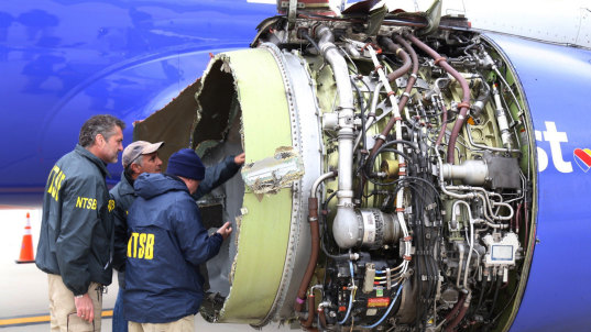 Investigators examine damage to the engine of the Southwest Airlines plane.