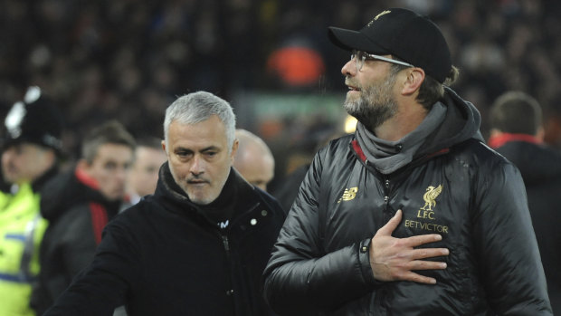 Contrast: Beaming Liverpool manager Jurgen Klopp (right) alongside his Manchester United counterpart.
