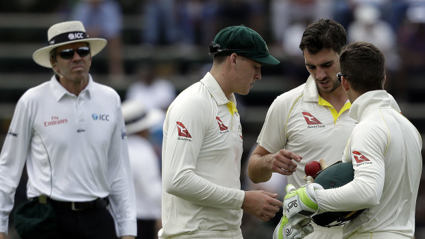 Inspection: Matt Renshaw, Pat Cummins and captain Tim Paine check the ball at the Wanderers stadium.