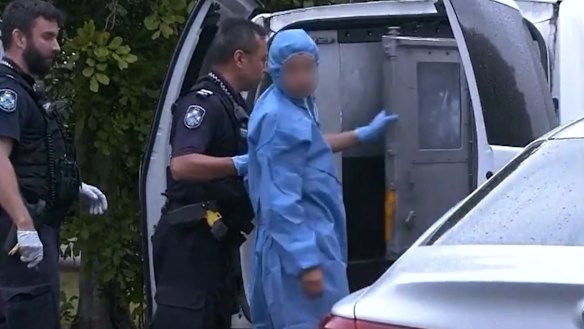 Officers lead a suspect into a police van after North Lakes mother Emma Lovell died of her injuries on Boxing Day.