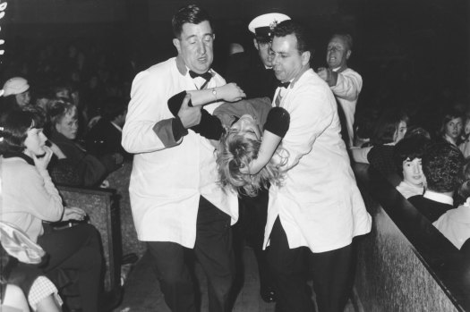 A fan leaves The Beatles’ Festival Hall co<em></em>ncert in 1964.