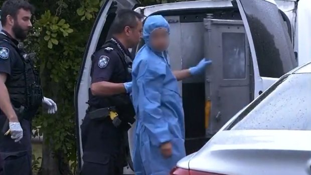 Officers lead a suspect into a police van after North Lakes mother Emma Lovell died of her injuries on Boxing Day.