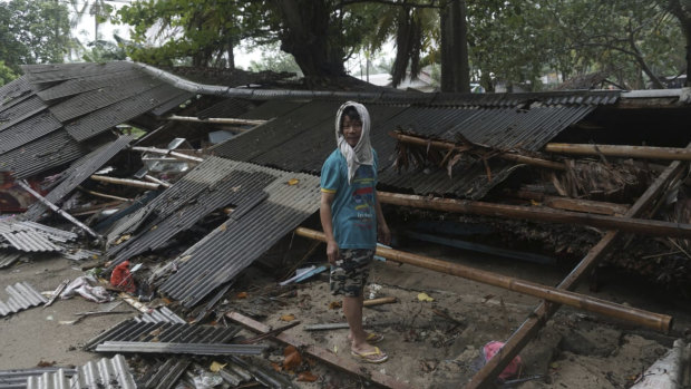 A man inspects his house which was damaged by the tsunami in Carita.