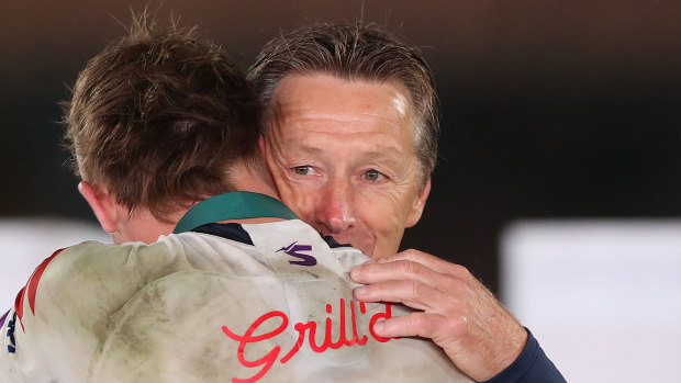 Craig Bellamy embraces Clive Churchill medallist Ryan Papenhuyzen.