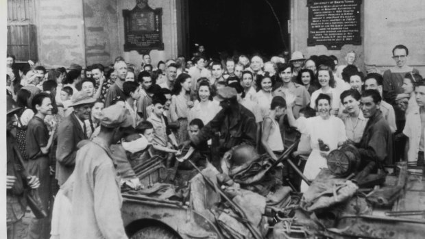 
Inmates of Santo Tomas internment camp, Manila, P.I., crowd around an American Jeep on February 11, 1945