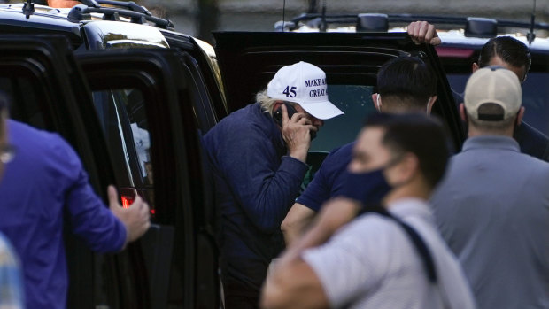 Trump was speaking on a phone as he got out of his vehicle on return to the White House.