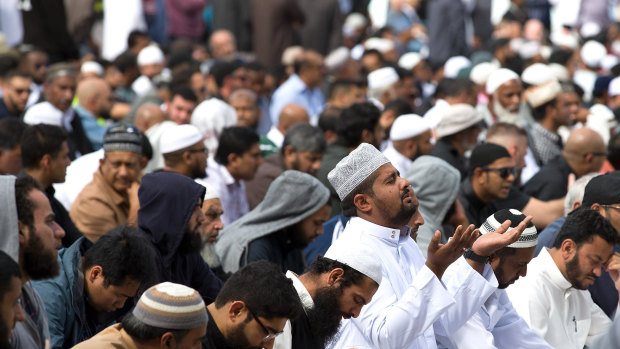 Muslims pray in the park opposite the Al Noor mosque, ahead of two minutes of silence that was to be recognised across New Zealand.