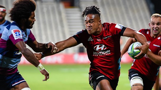 Leicester Faingaanuku of the Crusaders fends off Henry Speight of the Reds during their Super Rugby clash in Christchurch.