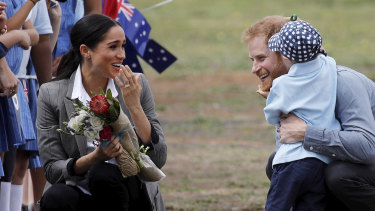 Britain's Prince Harry and Meghan, Duchess of Sussex are embraced by Luke Vincent, 5.