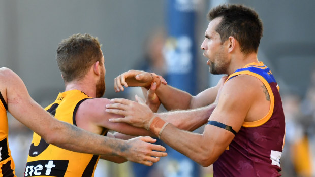 Battle of the ages: Veteran Luke Hodge takes on Hawthorn's Tom Mitchell.