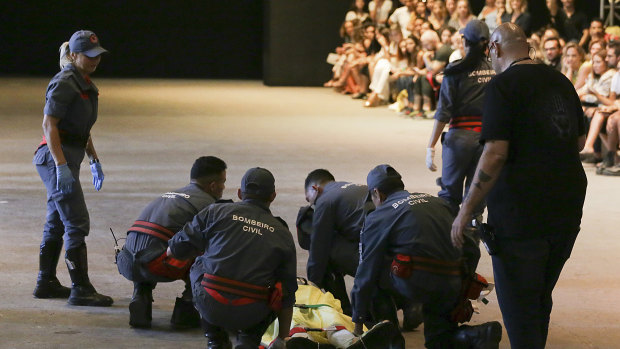 Model Tales Soares is taken from the catwalk by paramedics after he collapsed during Sao Paulo Fashion Week in Sao Paulo.