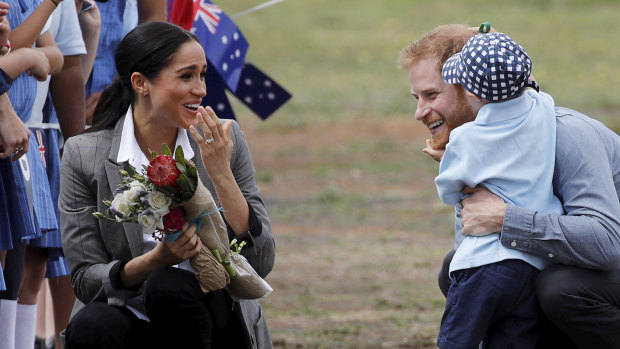Britain's Prince Harry and Meghan, Duchess of Sussex are embraced by Luke Vincent, 5.