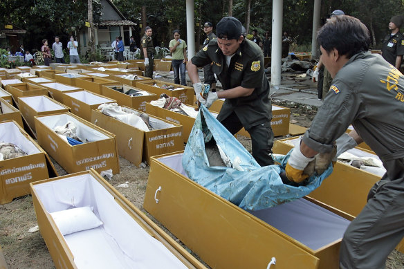 Volunteers load bodies into coffins  near Takuapa, Thailand, on December 28, 2004, two days after the Boxing Day tsunami.
