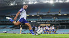 A rugby league match is being played in front of an empty stadium in Sydney on March 19 as Brendon Wakeham of the Bulldogs takes a conversion attempt. 