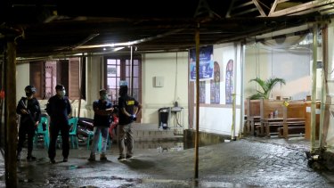 Members Indonesian’s anti-terrorism squad stand in front of a church hit by a bombing in Makassar, South Sulawesi in March. 

