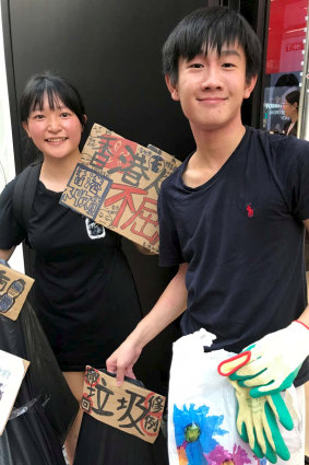 Picking up rubbish as they marched in Hong Kong were Ariel and Ethan, aged 17.