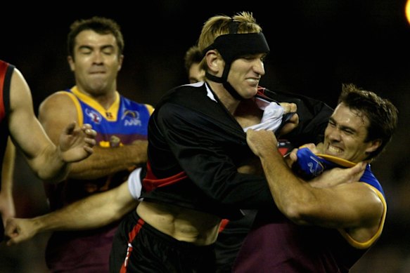 Brad Scott tussles with James Hird in their playing days 23 years ago while his brother, Chris Scott, enters the fray.