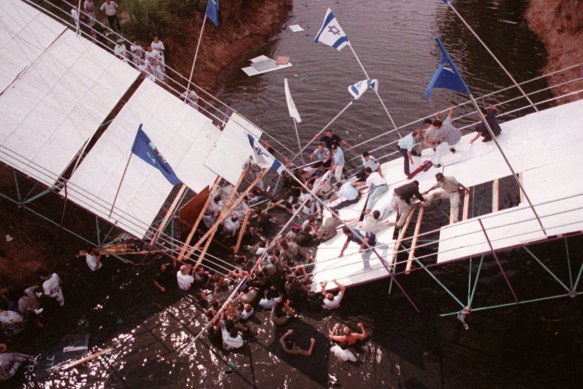 Israeli rescue workers evacuate members of the Australian team from a bridge at the Yarkon River in Tel Aviv Monday, July 14, 1997.