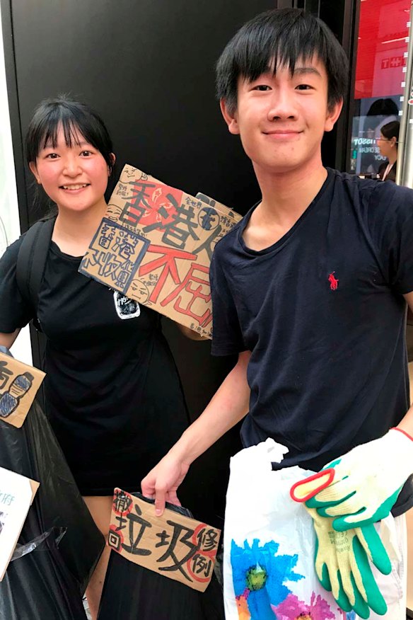 Picking up rubbish as they marched in Hong Kong were Ariel and Ethan, aged 17.