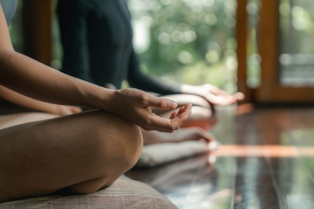 Two female friends practicing meditation at a wellness resort. Stock image.