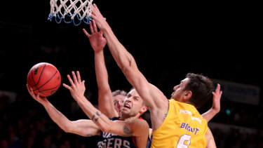 Drive to the basket: Nathan Sobey of the 36ers tries to get past Andrew Bogut.