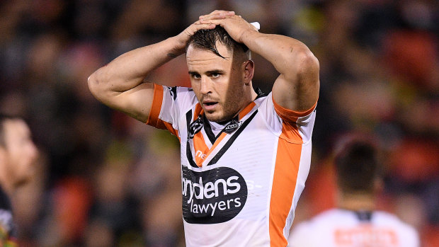Tigers playmaker Josh Reynolds has been charged with assaulting his former partner. He denies the allegation.