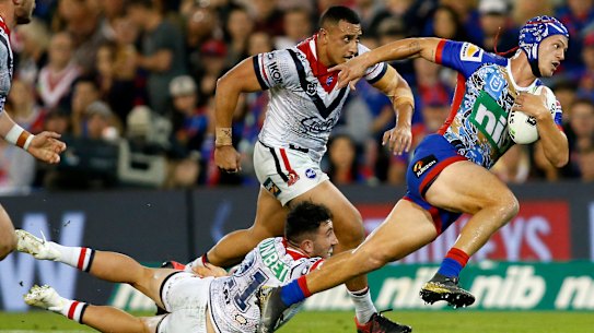 Danger man: Kalyn Ponga slips past Brock Lamb of the Roosters at McDonald Jones Stadium.