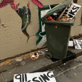 Protesters dispose of signs near Parliament House after the pandemic legislation passes.