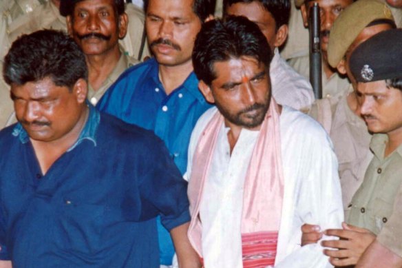Dara Singh, centre in white, is escorted from the court in Bhubhaneshwar, India, in 2003. His death sentence was later commuted to life.
