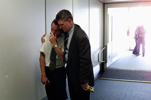 Micheal Basaranowicz being comforted by a collegue after seeing a flight depart. 