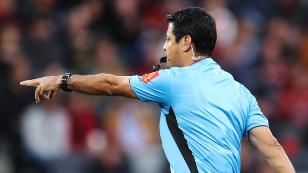 Referee, Alireza Faghani points to the penalty spot after reviewing a hand-ball with VAR.