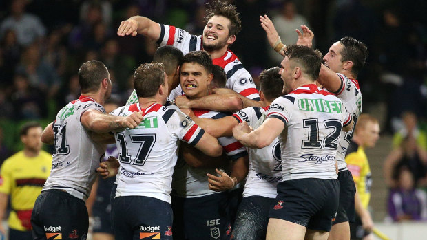The power of one: Latrell Mitchell (centre) is mobbed by teammates after the final play.