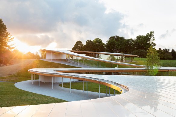 SANAA’s Grace Farms project in Connecticut, USA, meanders down a hill like a river.
Grace Farms project in Connecticut, USA, where a series of round glass buildings are dotted down a hill connected by a meandering roof and external path.