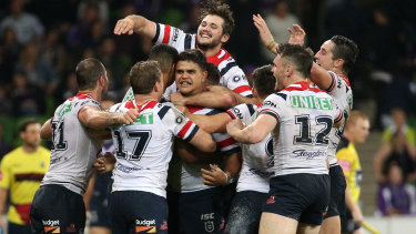 The power of one: Latrell Mitchell (centre) is mobbed by teammates after the final play.