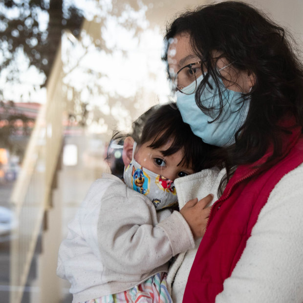 Leidy Castro Meneses with her daughter, Sofia, in the lobby of their Yagoona apartment building. She is relieved to be vaccinated now that the virus is raging in her local area.