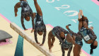 A digital composite of Simone Biles on the balance beam.