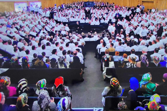 A recent service of the Plymouth Brethren Christian Church showing women at the back of the room, men at the front.