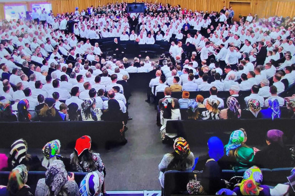 A recent service of the Plymouth Brethren Christian Church with women at the back of the room, men at the front.