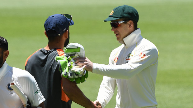 Tim Paine shakes hands with Virat Kohli after Australia won the second Test match in Perth.