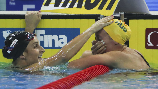A shocked Ariarne Titmus is congratulated by American Leah Smith after her 400m freestyle world title.