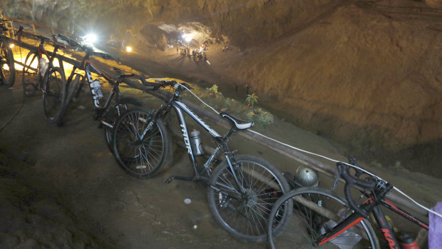 Bicycles left by a group of missing boys lean against a railing at the entrance of a deep cave in Chiang Rai, northern Thailand.
