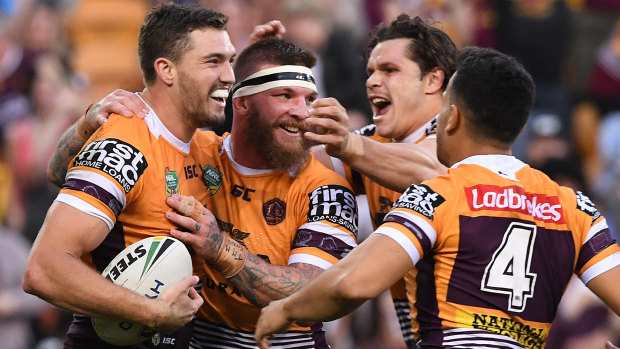 Prolific: Corey Oates celebrates with teammates after scoring again during his four-try romp.